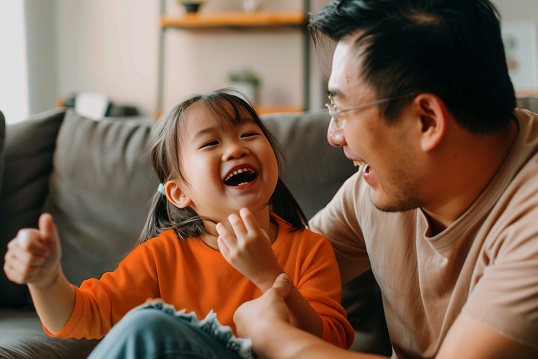 Father laughing with his daughter in the living room