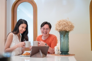 Friends having coffee and video call on a tablet in cafe